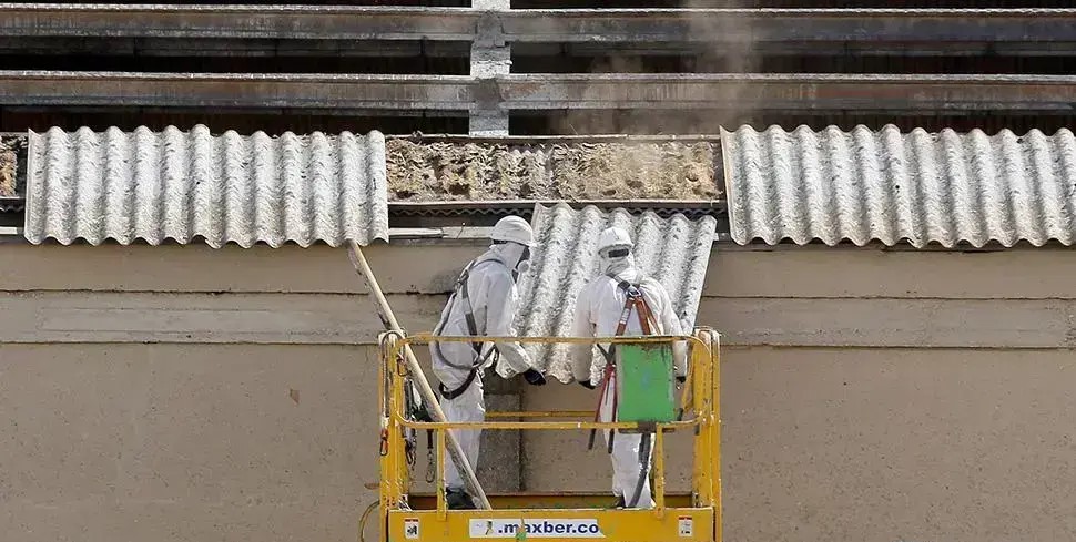 Dos trabajadores retiran placas de uralita (Foto: ICAL)