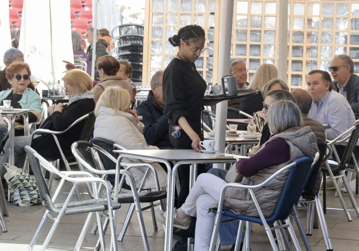 Una camarera sirve a una pareja en una terraza de la Plaza Mayor de Valladolid. Carlos Espeso