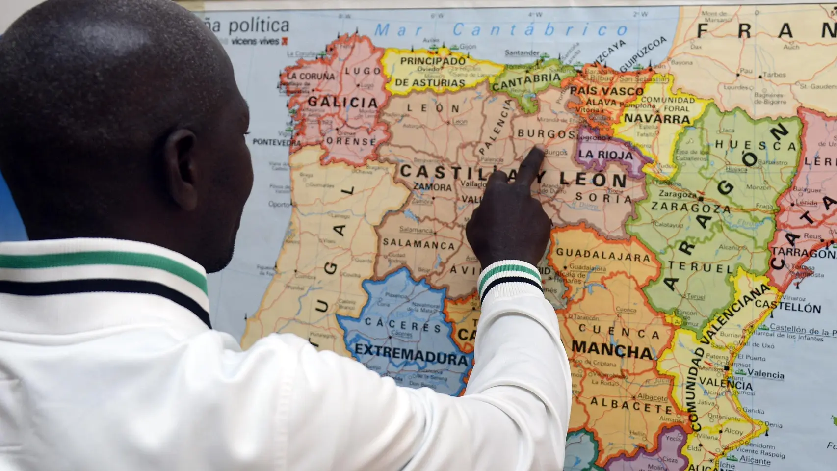 Un inmigrante señalando Castilla y León en un mapa Ricardo Ordóñez ICAL